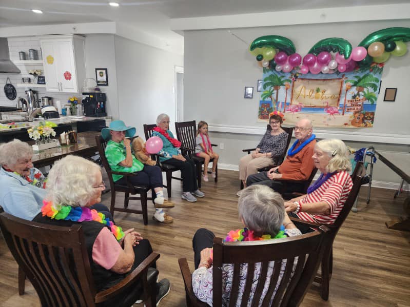 The family behind Two Hearts Homes for Seniors, smiling together in branded t-shirts, representing their commitment to compassionate, family-centered senior care.